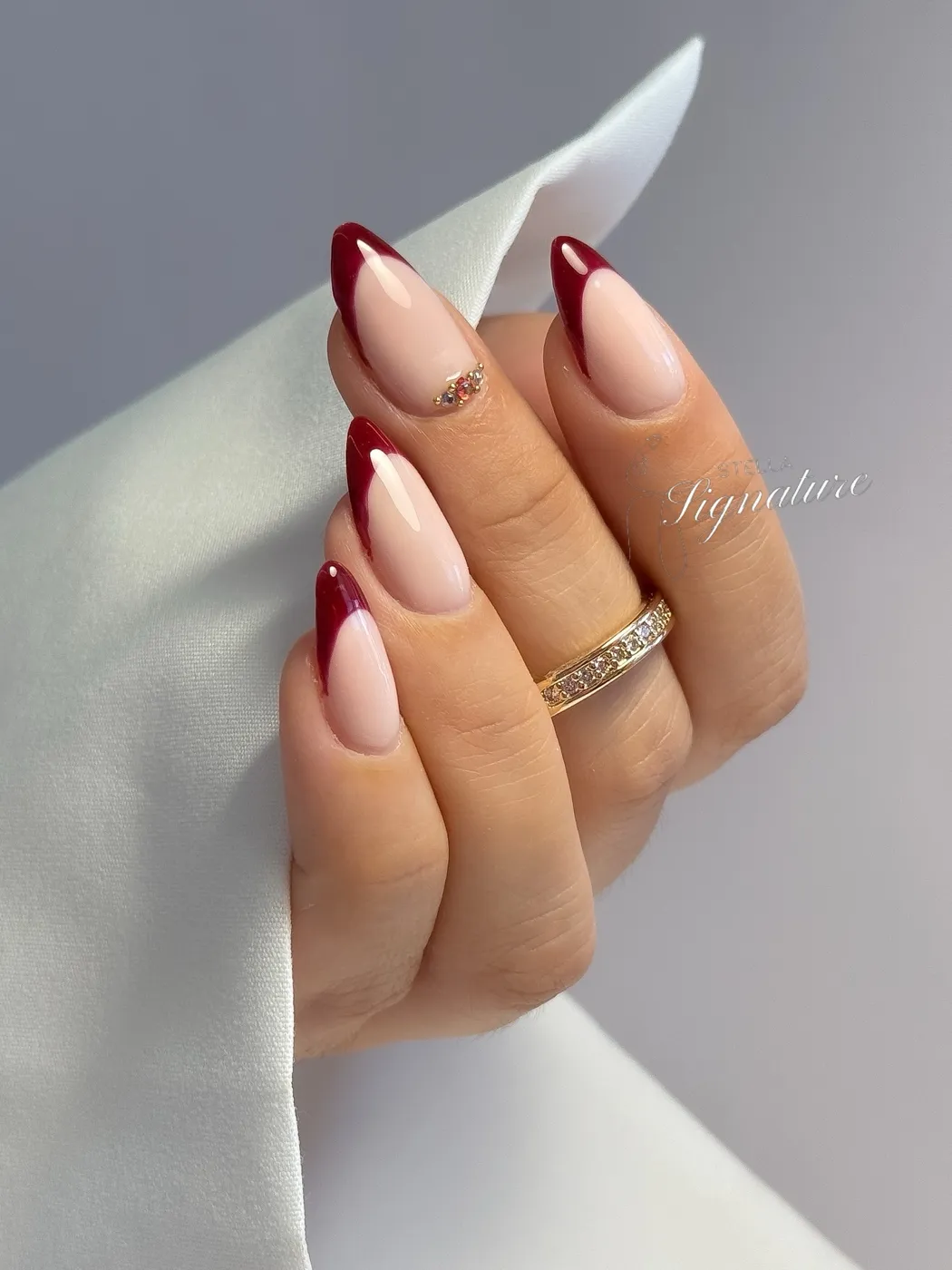 French bordeaux sur ongles amande, strass sur l'annulaire